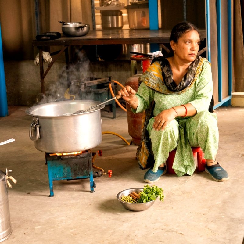 A sewadar lovingly cooking langar over the flame